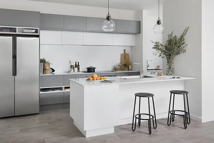 A transitional kitchen featuring grey and white cabinets, a white island, stainless - steel fridge, and black stools, titled “Transitional Cabinets”.