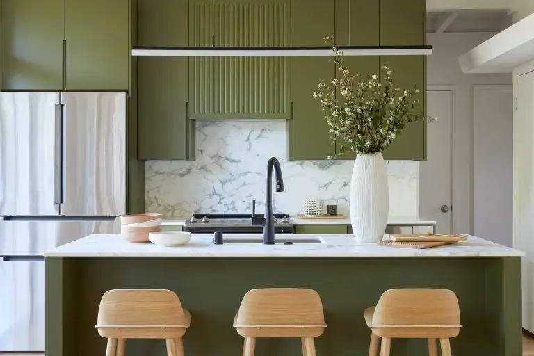 A modern kitchen with green cabinets, white countertop, stainless - steel fridge, and wooden stools, titled “Modern Cabinet”.