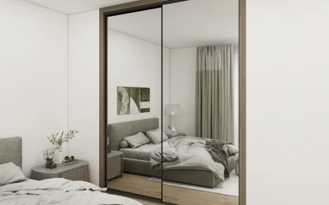 A bedroom with mirror - door cabinets, enhancing functionality and visual space.