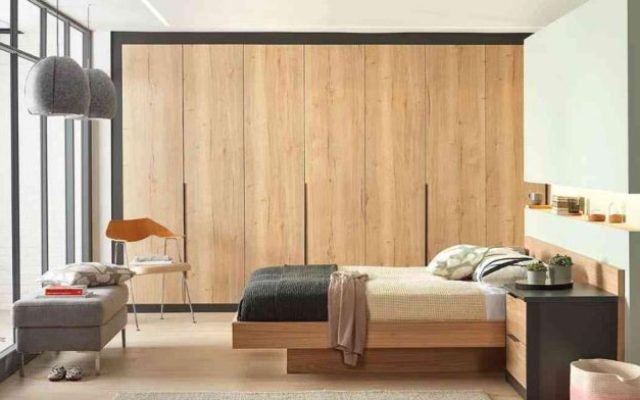 A bedroom displaying traditional cabinets with wooden finishes, embodying classic design elements.